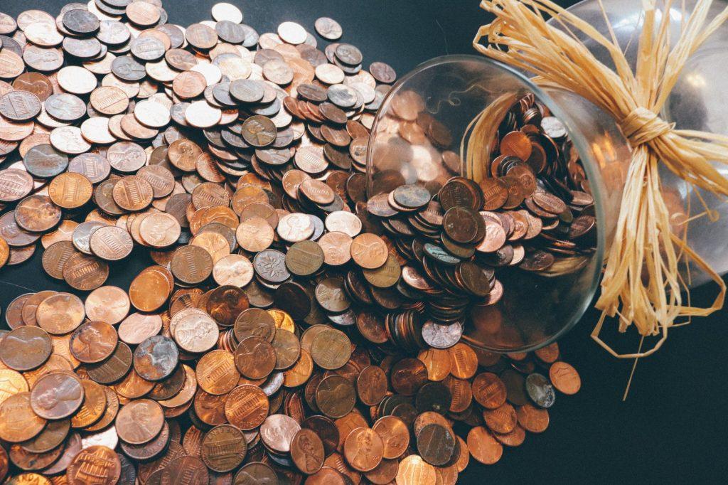 Coins spilling out of a jar. Affordable movers in Toronto will save you from having to dig into your piggy bank.