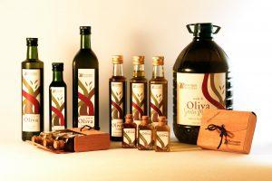 Many different olive oil bottles on a white surface.