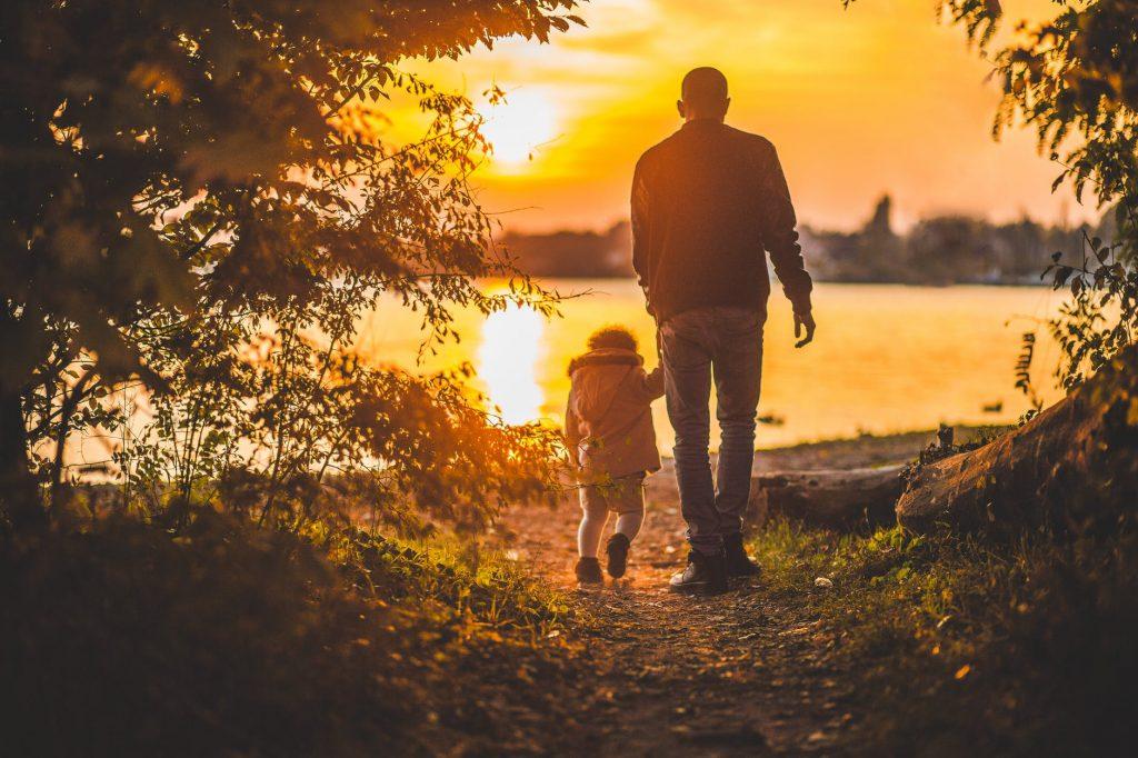 A photo of a man and a child in nature during sunset. By moving to Toronto with a family, you get to marvel at the sight of the amazing Canadian landscape.