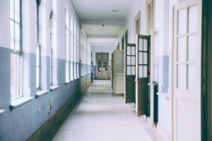 A hallway in the school with a couple of doors open. 