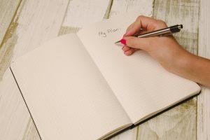 A woman holding a pen and writing in a notebook. The title is my plan, which means she might be making her perfect moving plan.