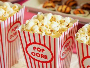 A close up picture of popcorn in a read and white container.