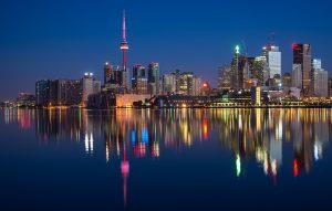 A view of the buildings in Toronto during night, seen from a body of water.