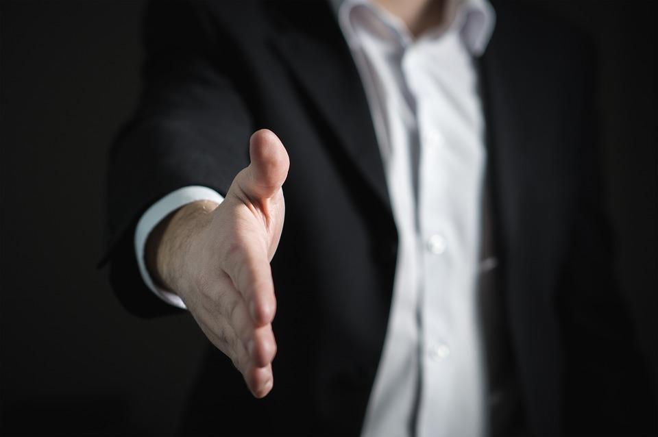 A businessperson, which is one of the highest paying jobs in Canada, offering a handshake.