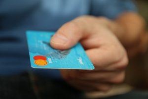 A hand holding a debit card. 