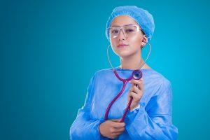 A doctor, which is one of the highest paying jobs in Canada, standing in front of a blue background. 