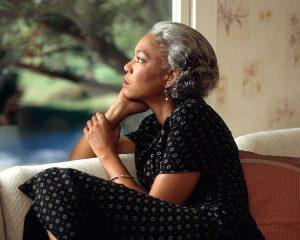 A woman thinking, wondering how to pack large items.