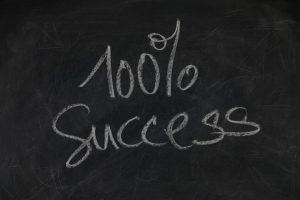 100% success written on a blackboard. 