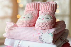 Pink baby boots and pink baby clothing.