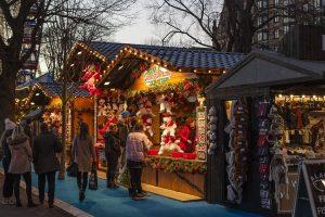 A few people at a Christmas market, and visiting it is one of the things to do during fall in Toronto.