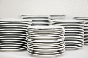 Stacks of white plates, to be included in your packing checklist. 