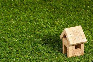 A model of a house on the grass. 